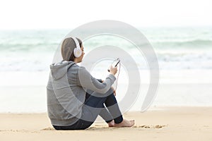 Longing teen alone listening to music on the beach
