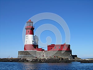 Longstone lighthouse with a blue sky in the background, in England, United Kingdom