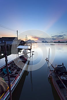 longtail boat with coastal fishing village ,Beautiful morning sunrise over sea and mountain in phang - nga thailand.