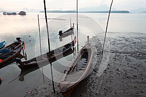 Longtail boat with coastal fishing village scenery view in morning sunrise over sea and mountain at phang - nga thailand