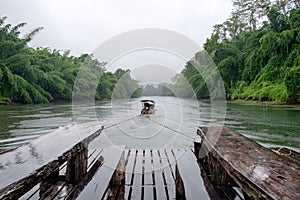 Longtail boat drag wooden raft in river kwai