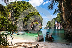 Longtail boat on the shore of a tropical island, surrounded by c