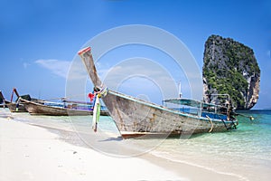 Longtail boat on white sand beach and landmark at Po-da island