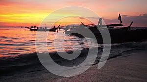 Longtail boats on seashore at sunset