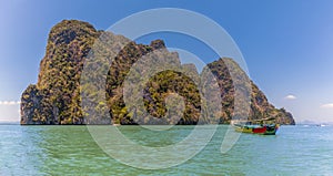 A longtailed speed boat moored of an islet in  Phang Nga Bay in Thailand