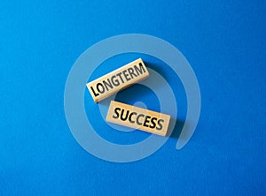 Longterm success symbol. Wooden blocks with words Longterm success. Beautiful blue background. Business and Longterm success
