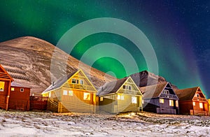 Longyearbyen colorful houses with Aurora Borealis in the sky full of stars