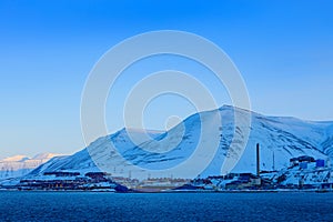 Longyearbyen, holiday travel in Arctic, Svalbard, Norway. People on the boat. Winter mountain with snow, blue glacier ice with sea