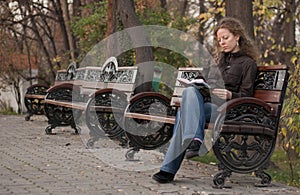 Lonley girl in a park reading