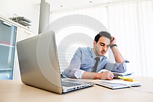 Lonley tiresome businessman spending time at work