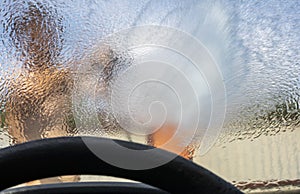 Look through the blurred windshield of a car at a heavy downpour, flood