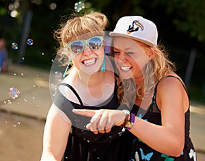 Look A bubble. two female friends having fun at an outdoor festival.