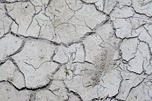 Look down on crack dried mud surface of the ground.