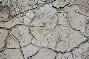 Look down on crack dried mud surface of the ground.