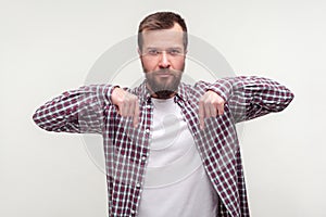 Look down, here and right now! Portrait of bossy strict bearded man pointing fingers down. white background