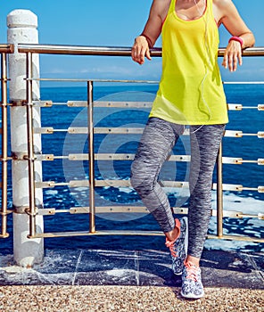 Healthy woman in fitness outfit looking aside at embankment