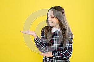 Look here. Product presentation. Small girl nice hairstyle. Child long curly hair. Happy schoolgirl stylish uniform