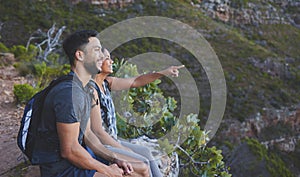 Look at how amazing that view is. Shot of a young couple enjoying the sunset view while out on a hike on a mountain