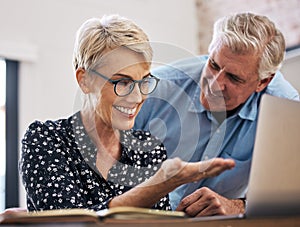 Look at how great this looks. a mature couple using a laptop at home.