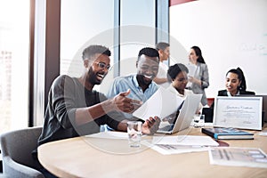 Look at how our profits have skyrocketed. Shot of two businessmen going through paperwork together in an office with