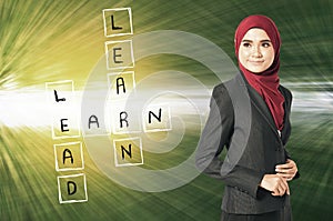 Look at Learn, lead and earn word box on her left over abstract background