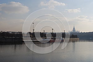 Look the Moskva River with the moored walking yacht against the background of MSU.