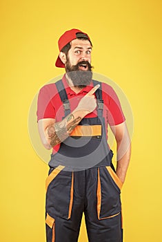 look over here. professional delivery loader service. confident in uniform. working on construction site. bearded male