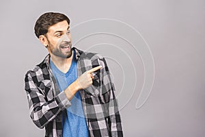 Look over there! Happy young handsome man in casual pointing away and smiling while standing