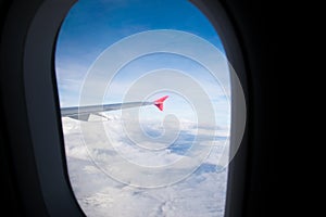 Look through the plane window and white cloud and blue sky