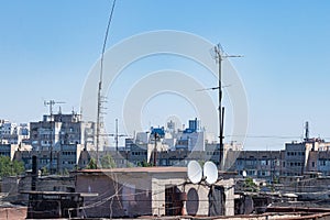 A Look at The Rooftops in One of the Urban Residential Areas. Many Intersecting Wires and Cables Are Visible, Satellite Dishes and