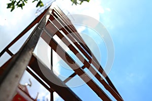 Look up on the steel stairs, sky background, clouds and sunlight.