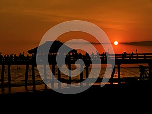 Amazing beach sunset behind the pier photo