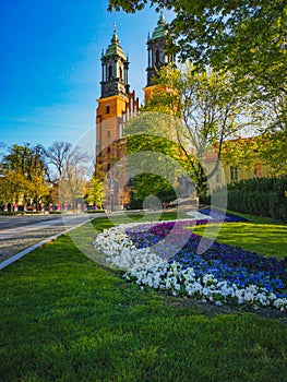 Look to small colorful garden in front of Basilica of Saint Peter and Paul in Poznan City at sunny morning