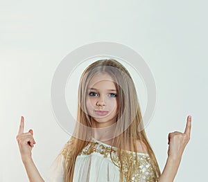 Look up here. Portrait closeup of funny excited girl female child kid smiling girl long hair looking at you pointing showing up