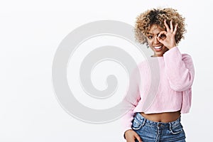 Look who there. Joyful charismatic and happy attractive stylish dark-skinned girl in warm sweater showing no problem