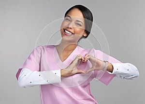 Look after your heart. Cropped portrait of an attractive young female healthcare worker gesturing a heart shape with her