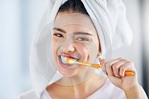 Look after your smile. Portrait of a beautiful young woman brushing her teeth in the bathroom at home.