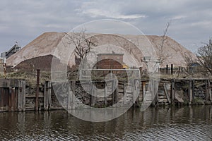 Looking across a river at a pile of rock salt