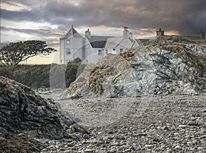 Looking across a stoney beach at a house