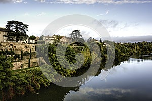 Looking across the Tarn River in Lisle-sur-Tarn under blue skies wirh scattered clouds