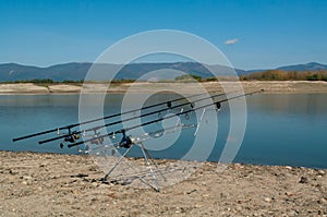 Looking along three carp rods towards a pond. Carp fishing.