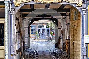 Looking through arched doors in an old building to a shop in the back yard