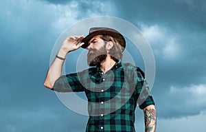 Looking away. brutal hipster with moustache in hat. fashion model wear casual west clothes. male beauty standard