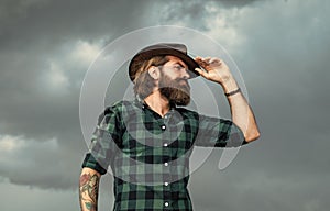 looking away. brutal hipster with moustache in hat. fashion model wear casual west clothes. male beauty standard