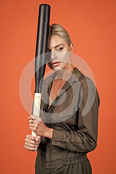 looking away. rounders game. woman in boilersuit with bat. female baseball player
