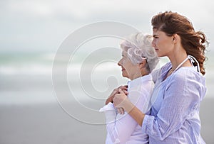 Looking back on their love-filled years together. Shot of a beautiful young woman and her senior mother on the beach.