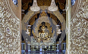 Looking through the beautiful architecture temple door of The golden buddha image within Wat Phra That Doi Phra Chan in Lampang