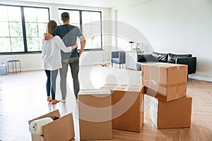 Looking at the big windows. Young couple moving to new home