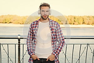 looking confident. quality of sound. innovative wireless device. unshaven guy with ear stereo headphones. male casual