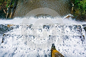 Looking down at the flow of water falling over a concrete dam, San Francisco bay area, California